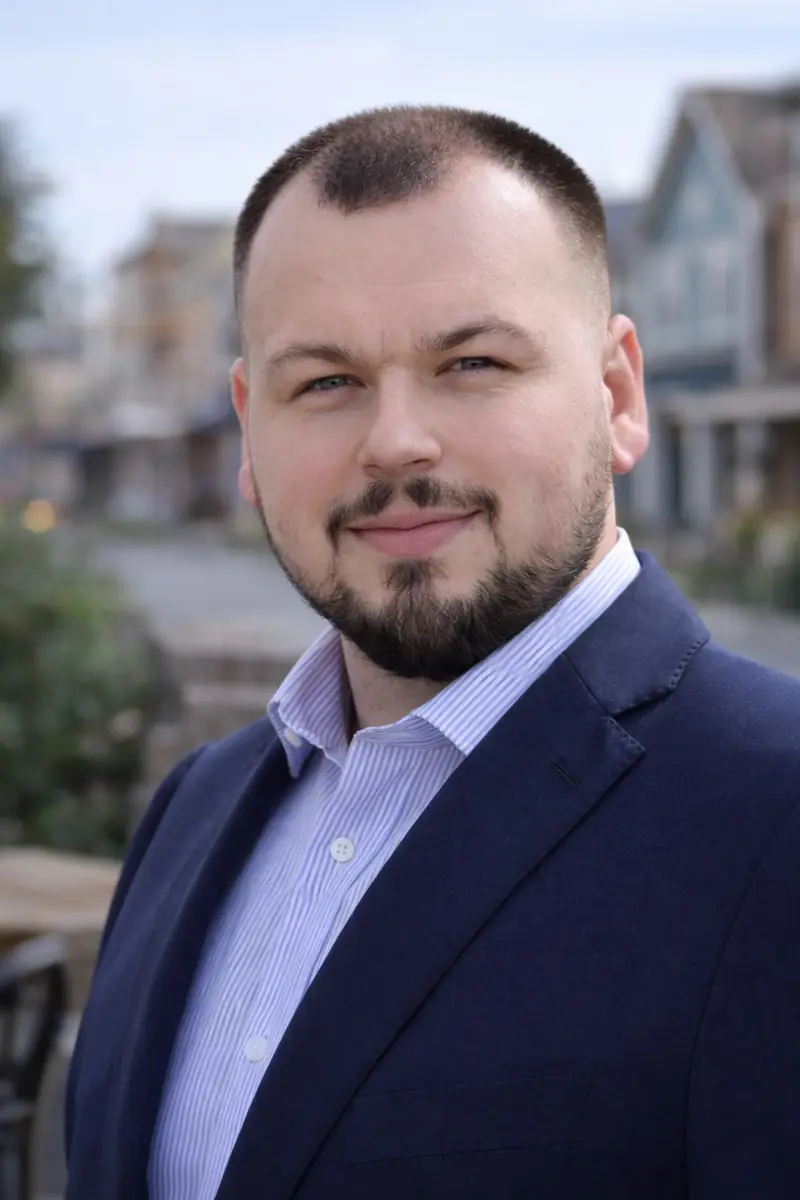 Portrait of Max Petrov outdoors in a navy blazer