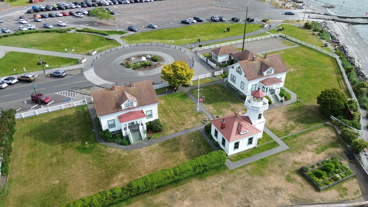 Aerial view of Mukilteo Lighthouse Park, with the white lighthouse, historic quarters, and the shoreline beyond